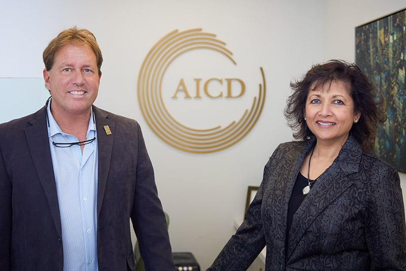 Dr. Robert Castracane and a dental team member at Advanced Implant & Cosmetic Dentistry (AICD), showcasing a welcoming environment for dental implant consultations.